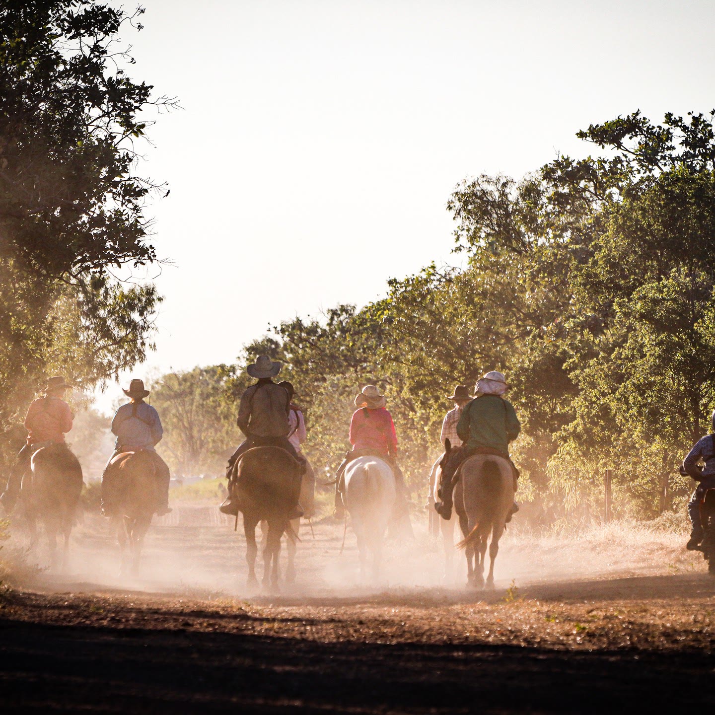 Riders heading down a dusty track at first light